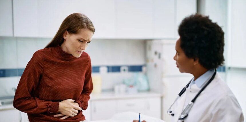 Female Patient Holding Her Abdomen In Pain While Talking To Her Doctor At Medica Clinic.jpg