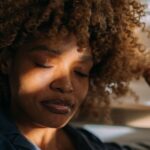 African American Woman In Pajamas Resting In Her Bed At Home.jpg