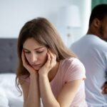 Upset Caucasian Woman Sitting Back To Back On Bed With Her Black Husband.jpg